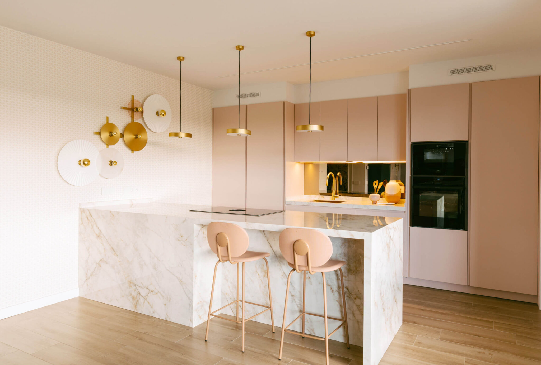 Cocina abierta decorada en tonos rosados y dorados por los interioristas y decoradores de Habitaka en Vitoria Gasteiz.