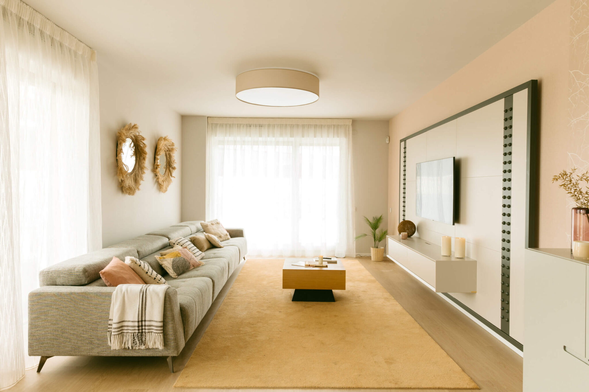 Salón decorado en tonos beige con sofá gris.