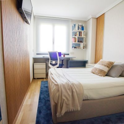Dormitorio juvenil decorado en tonos beige y azules.
